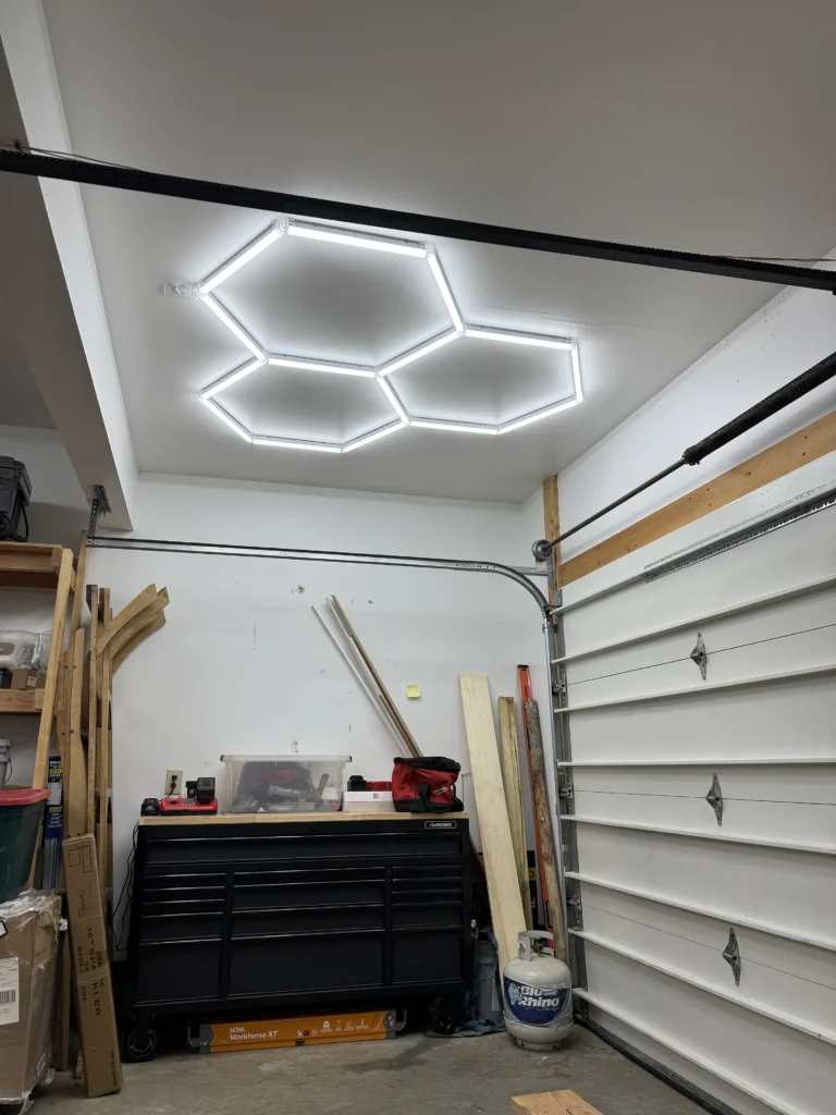 Hexagonal LED lights mounted to the ceiling of a home garage/gym